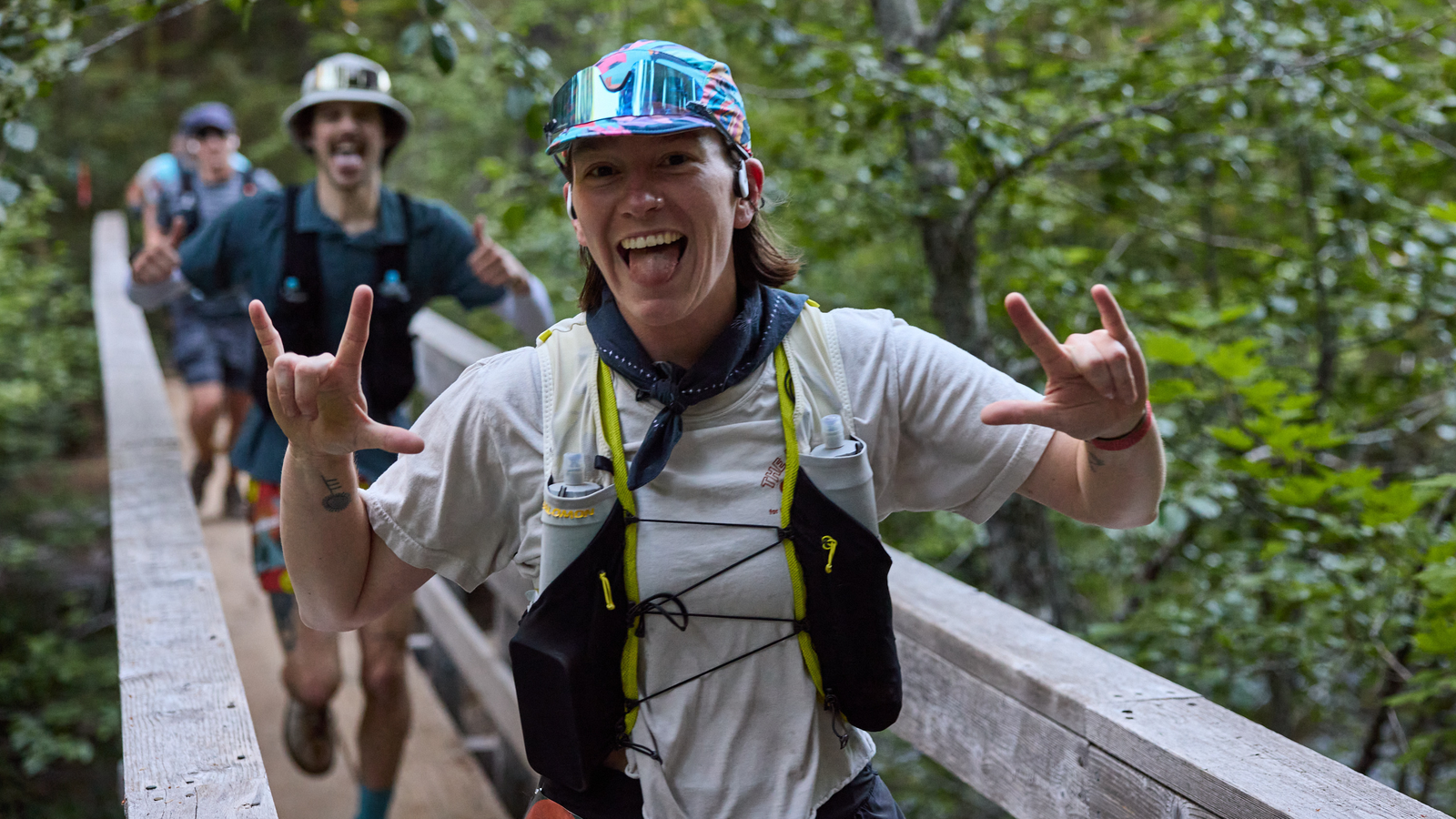 Sadie sticks her tongue out at the camera as she runs past in a trail race